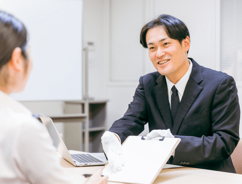 パソコンの前でお客様と話すスタッフ