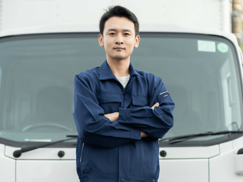 トラックの前でポーズする男性